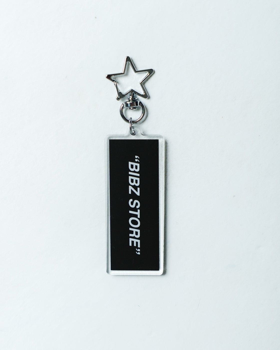 A rectangular black keychain tag with white vertical text reading 'BIBZ STORE' and a silver star-shaped keyring at the top, shown on a plain white background.